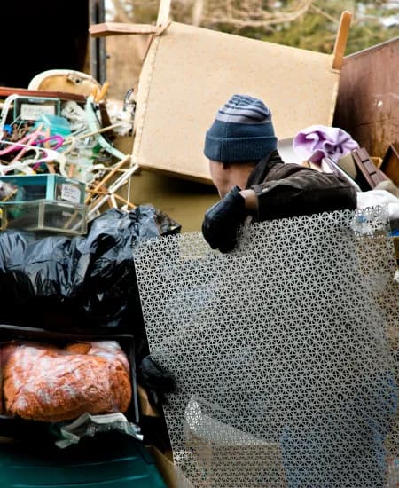 A worker clearing junk and debris for removal